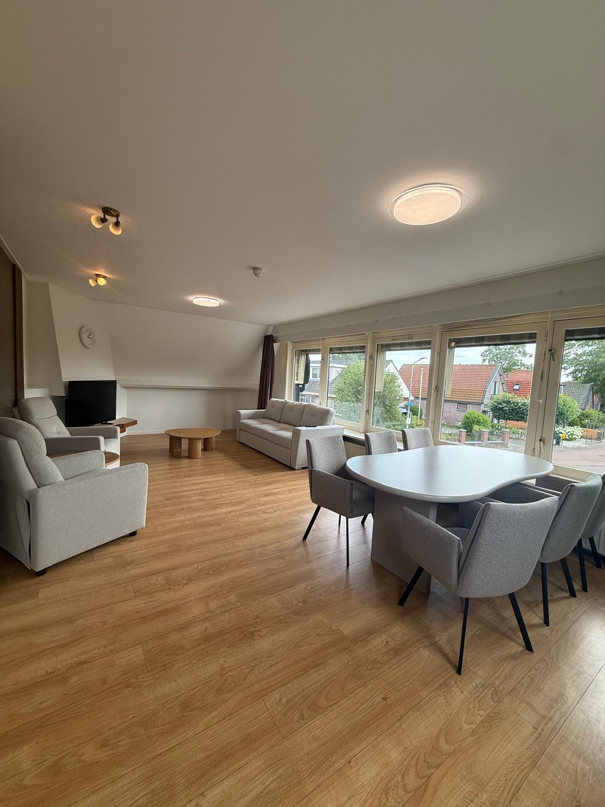 Ruime gemeenschappelijke woonkamer met eettafel en zithoek