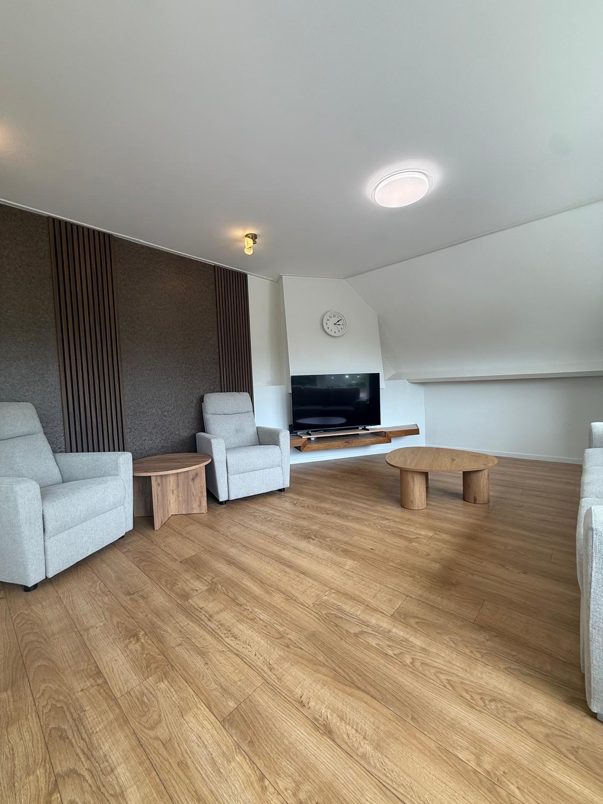 Huiskamer met relaxfauteuils, televisie en salontafel